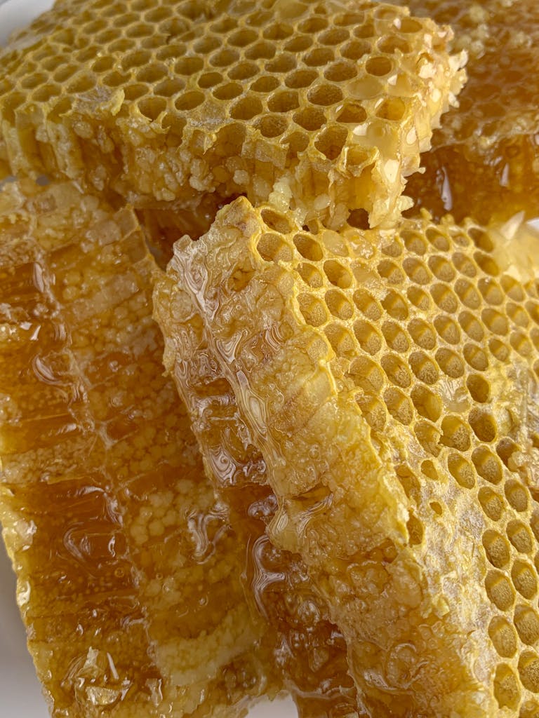 Detailed macro shot of fresh honeycomb dripping with golden honey, showcasing natural sweetness.
